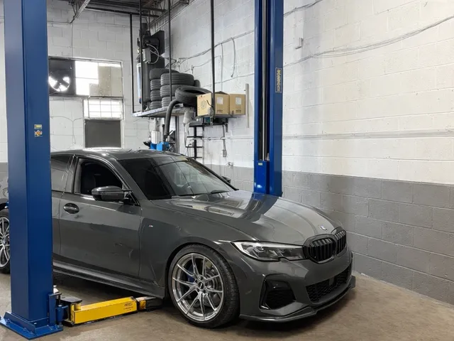 Shop bay setup with a vehicle on a two-post lift at Reliable Motorsports