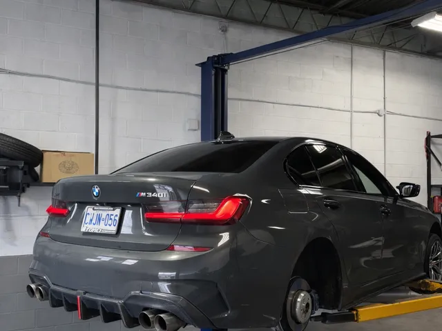 Two-post vehicle lift in the Reliable Motorsports shop bay